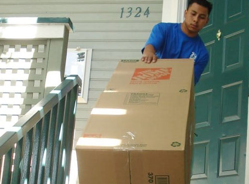 Spartan mover carries a box into a home.